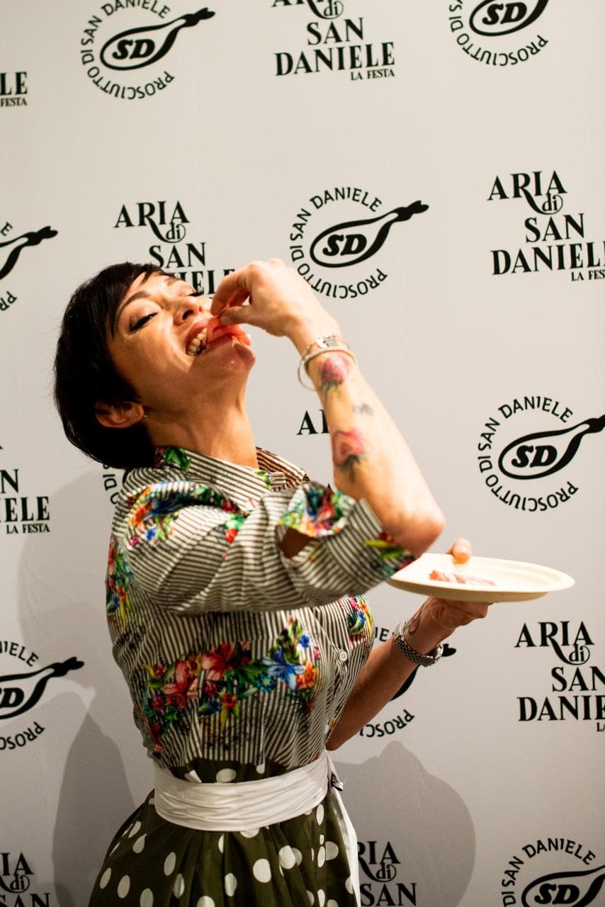 Rubina Rovini assaggia una fetta di Prosciutto di San Daniele durante la festa Aria di San Daniele.