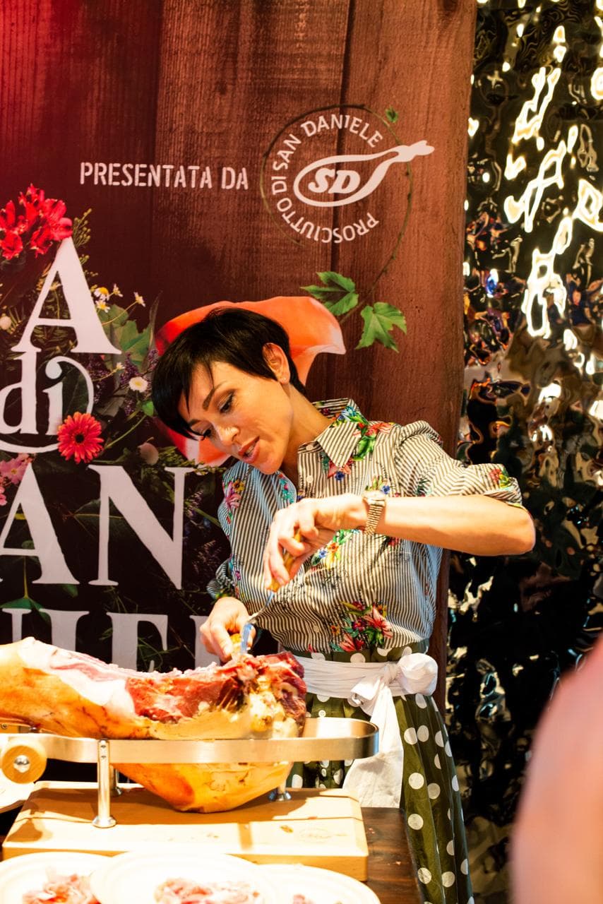 Rubina Rovini affetta a mano una coscia di Prosciutto di San Daniele allo stand della manifestazione.