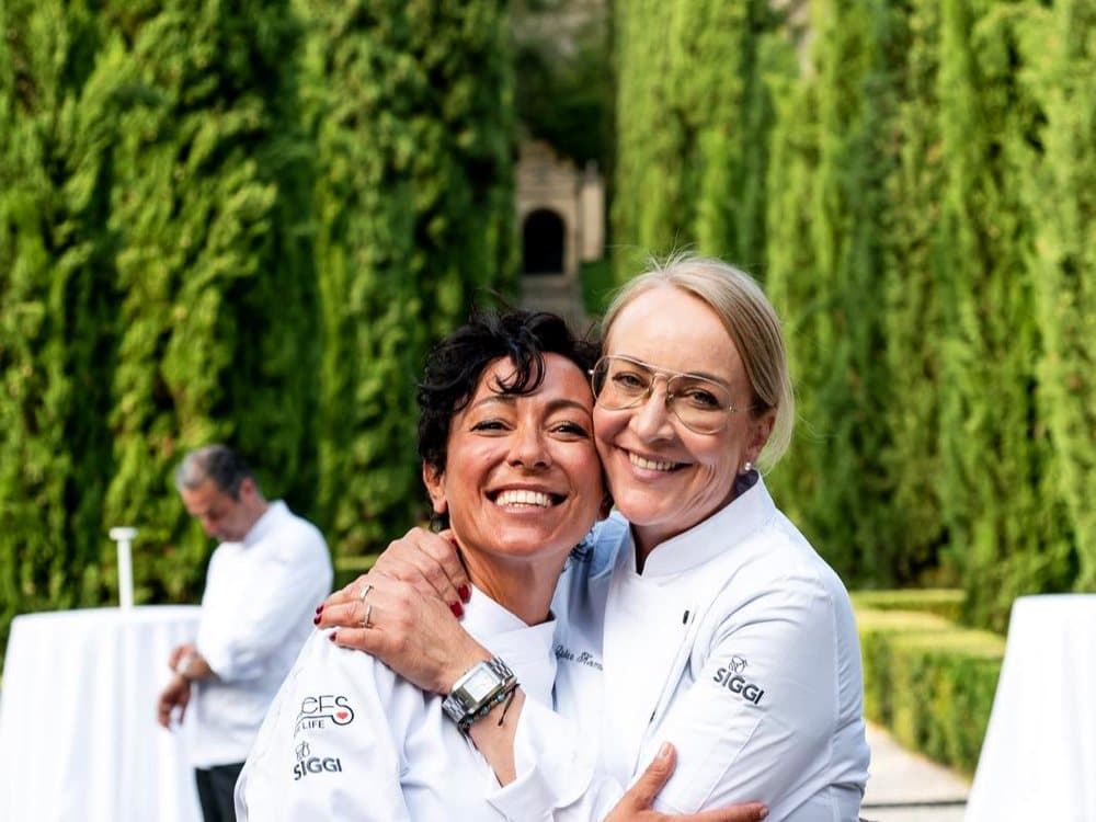 Rubina Rovini abbracciata a una collega chef nel Giardino Giusti di Verona, durante la serata benefica Chefs for Life.