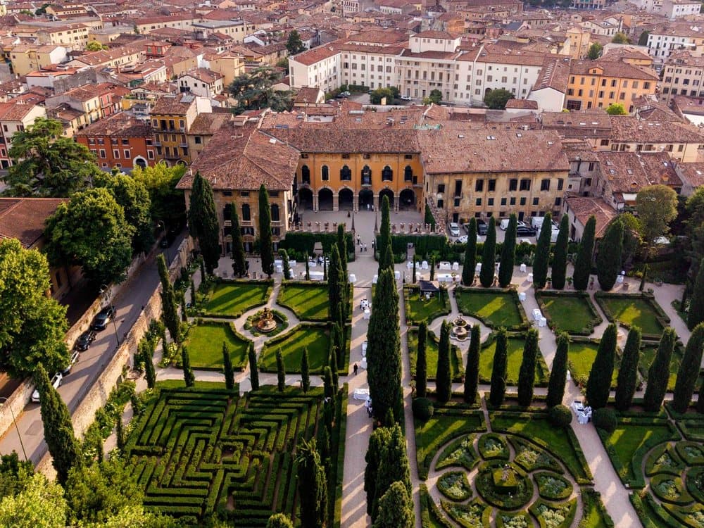 Veduta dall'alto del Giardino Giusti di Verona, con il labirinto di siepi e i tavoli allestiti per la serata.