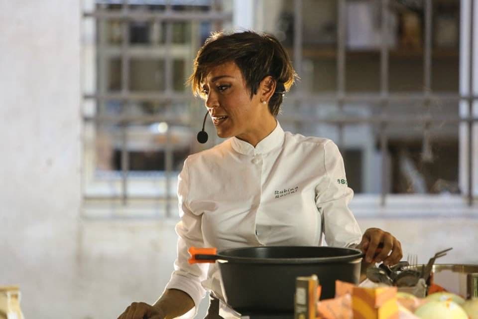 Rubina Rovini cucina al banco dimostrativo con i meloni mantovani in vista.