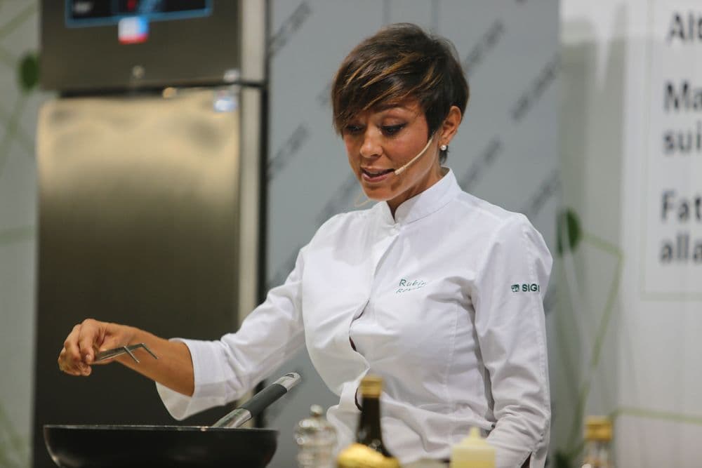 Rubina Rovini al fornello durante una dimostrazione in fiera.
