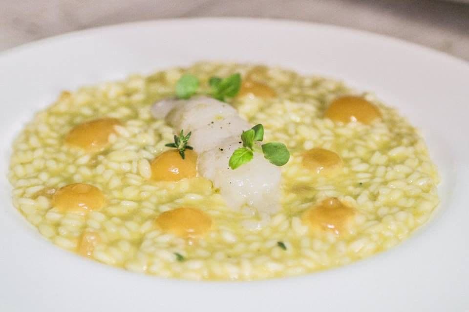 Risotto mantecato con perle di melone mantovano e pesce crudo.