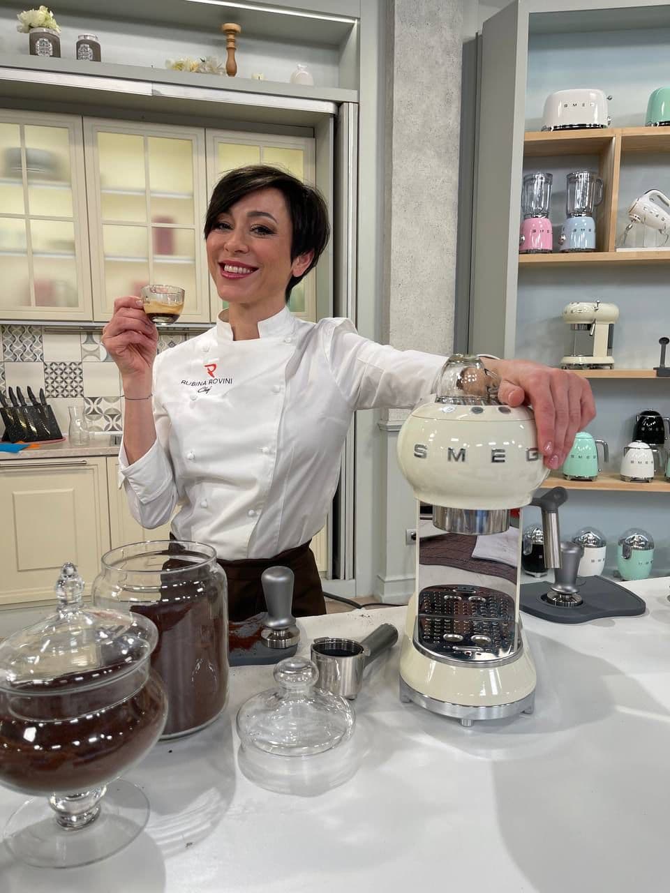 Rubina Rovini con la macchina del caffè SMEG sul bancone della cucina.