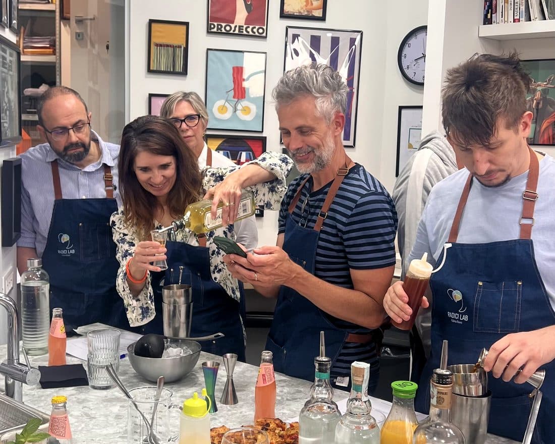 Partecipanti preparano e assaggiano cocktail attorno al banco durante una serata del Club RADICI.