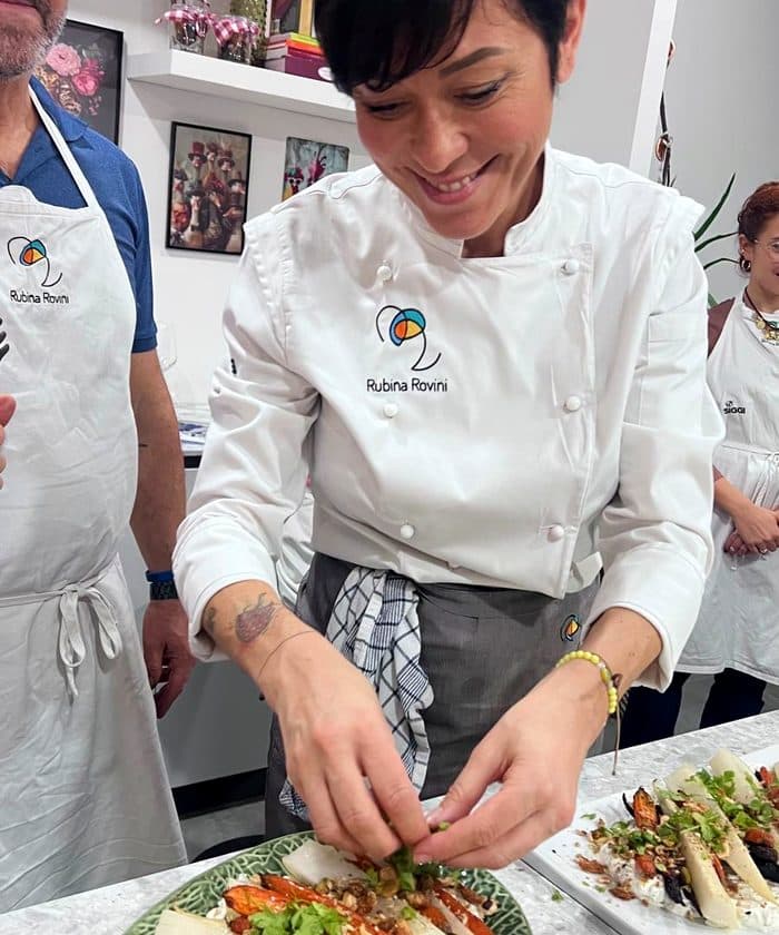 Rubina Rovini rifinisce un grande piatto di mare durante una serata in RADICI Lab.