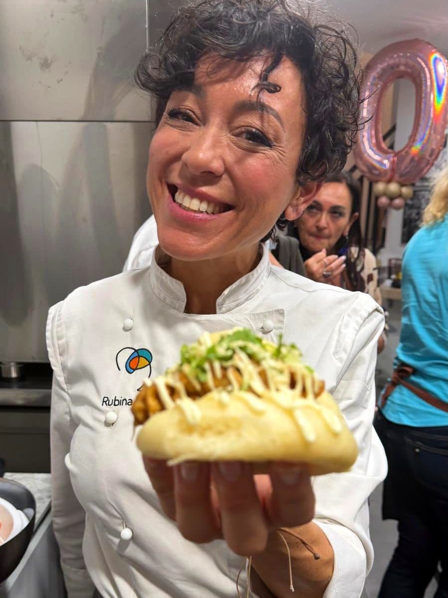 Rubina Rovini sorride mostrando un panino bao appena farcito durante una serata in RADICI Lab.