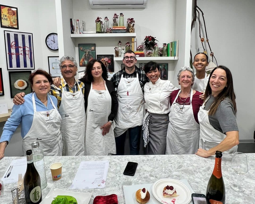 Il gruppo di un'Esperienza RADICI posa sorridente dietro al bancone di RADICI Lab, a fine serata.