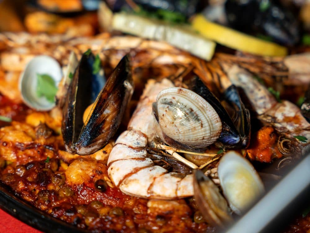 Paella di mare con cozze, vongole e gamberi, servita nella padella durante un'Esperienza RADICI.